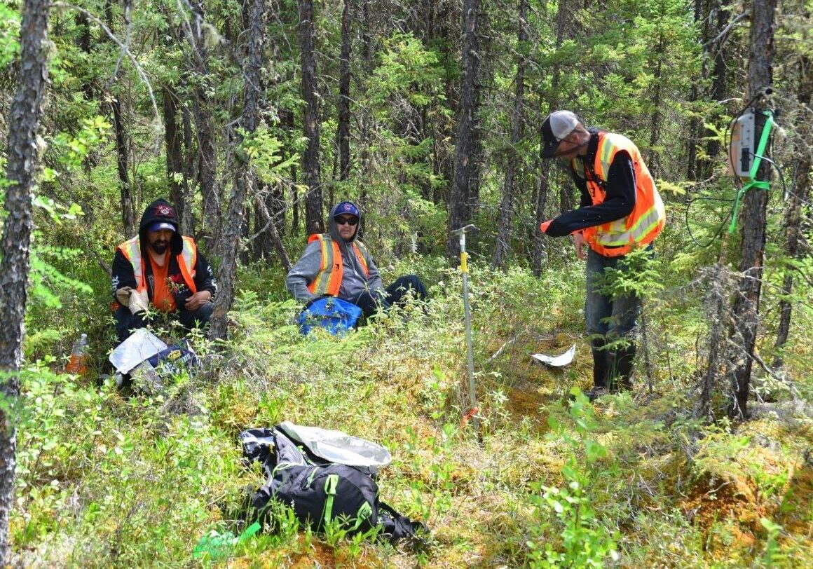 A photo of workers conducting soil sampling and field studies analysis.