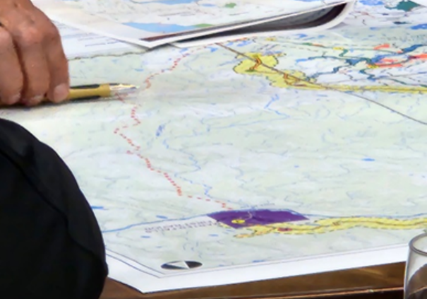 A photo of a person reviewing a map of a field study.